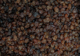 Background of lined dark raisins. Top view of the oriental treats. Fruit texture.