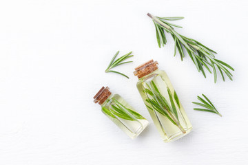 Organic cosmetics with extracts of herbs rosemary on white wooden background.