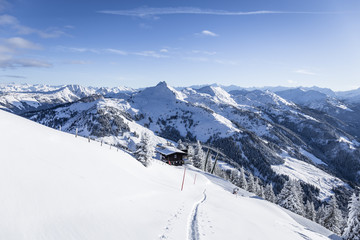Skitour auf den Gipfel mit Spur und Lift im Hintergrund im Winter
