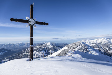 Gipfelkreuz im Winter mit Ausblick auf die Berglandschaft