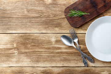 Cooking background concept. Vintage cutting board, plate and cutlery. Top view with copy space.