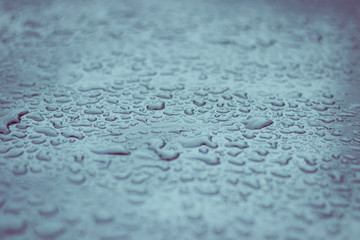 Drops of water on a blue metal. Toned