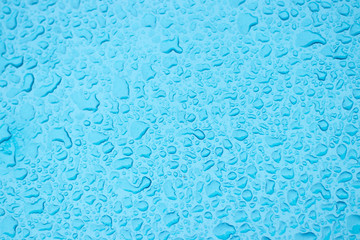 Drops of water on a blue metal.