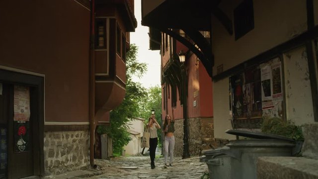 Wide shot of women walking and admiring architecture / Plovdiv, Bulgaria