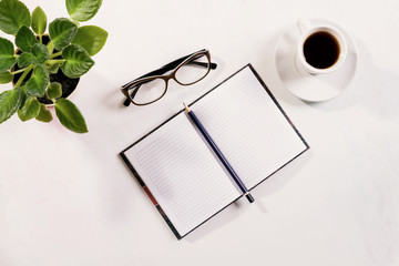 notebook with glasses and coffee on table