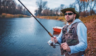 Fotobehang Angler enjoys in fishing on the river. Sport, recreation, lifestyle © bobex73