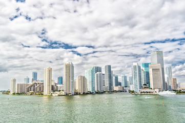 Aerial view of Miami skyscrapers with blue cloudy sky, boat sail