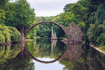 Rakotzbrücke (Rakotzbrucke) auch bekannt als Teufelsbrücke in Kromlau, Deutschland. Die Spiegelung der Brücke im Wasser erzeugt einen Vollkreis.