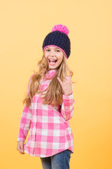 Girl in hat, plaid shirt on orange background