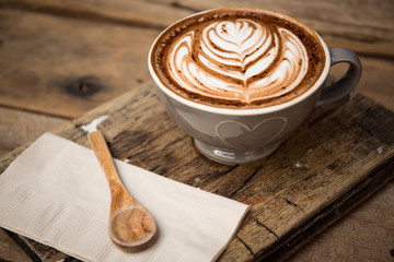 Cup of hot latte art coffee on wooden table
