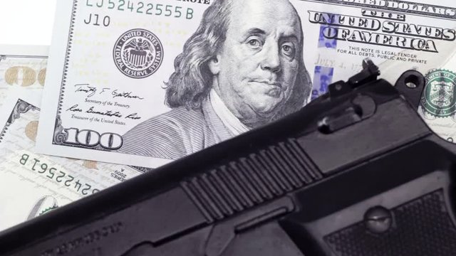 Cash one hundred dollar bills under the gun, rotating background