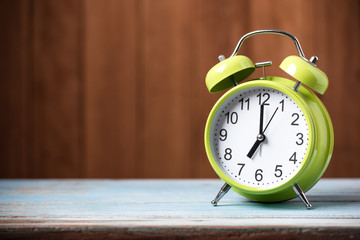 Retro alarm clock on wooden board