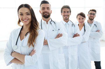 Portrait of medical team standing with arms crossed in hospital