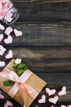 Marshmallow hearts, love letter and flowers on an old wooden background