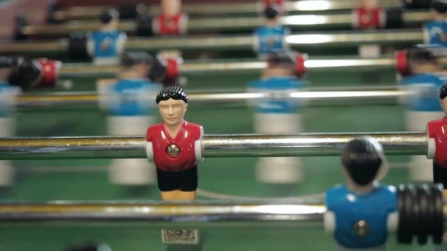 figures of footballers move left and right people playing foosball. table soccer plaers. table football soccer game kicker close up
