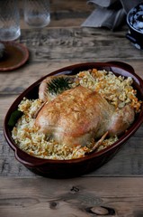 On a dish, baked chicken with rice and vegetables