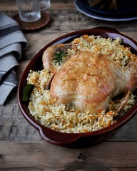 On a dish, baked chicken with rice and vegetables