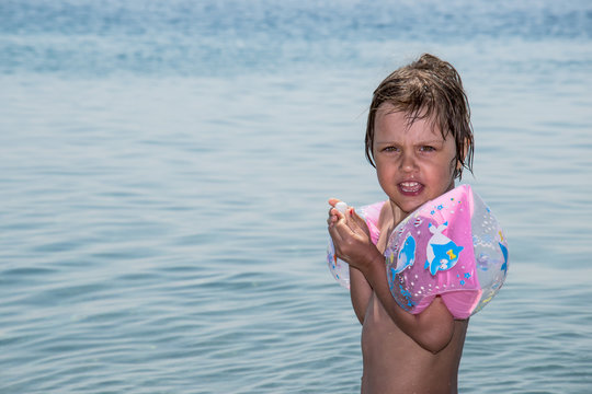 girl at sea with inflatable armbands
