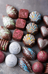 Colored chocolate candies. Creative sweets on a gray background.