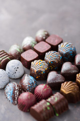 Colored chocolate candies. Creative sweets on a gray background.