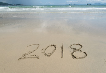 2018 written in sand write on tropical beach