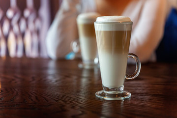 Latte macchiato in tall glass close up. Coffee on a table in cafe