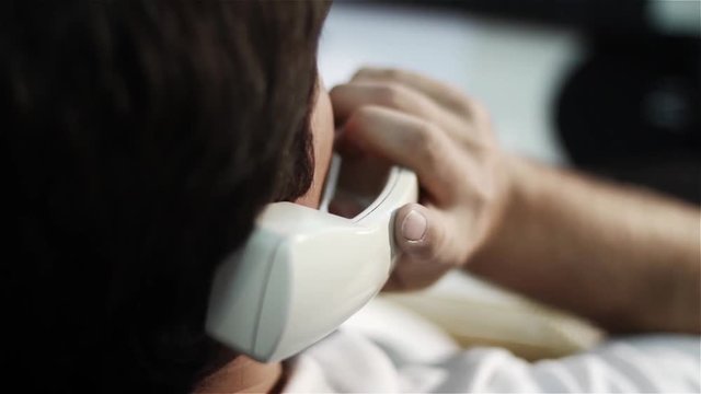 Back View of Office Worker Answering Vintage Landline Phone