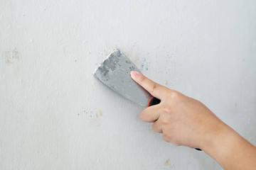 Asian female hand Making and repairing the wall. To prepare a new paint. as background interior decoration concept with copy space.