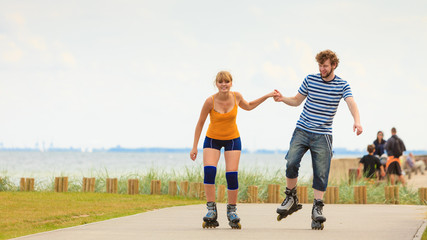 Young couple on roller skates riding outdoors