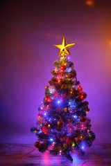 Christmas tree with festive lights, purple background