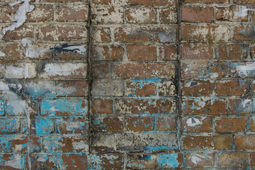 Fototapeta premium The texture of the cracked wall with the stucco plaster on the brick