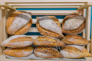 Freshly baked bread in hand and in wooden boxes