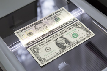 Paper money on the glass scanner. Checking paper dollars with a scanner for authenticity, protection from counterfeiters