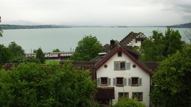 Swiss train passing Lake Zurich Zürichsee view of iconic village homes Richterswil in Switzerland 