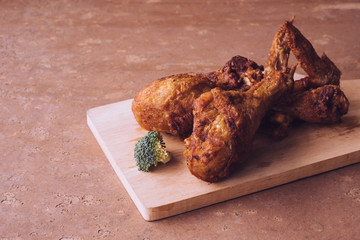 Fried chicken legs and wings on wooden tray.