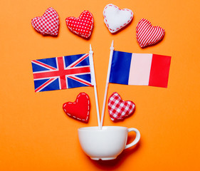 Obraz premium White cup and heart shapes with France and United Kingdom flags
