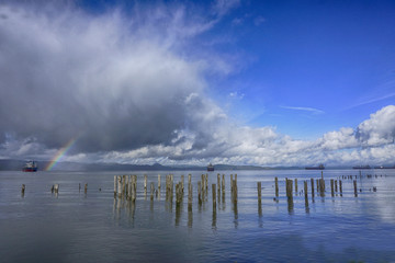 Cargo ships and rainbow at the East Mooring basin on the Columbia river in Astoria, Oregon