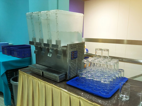 water cooler machine with glass on table in office.