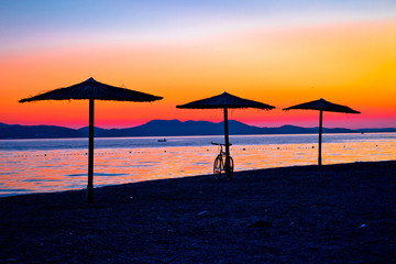 Beach and parasols on colorful sunset view