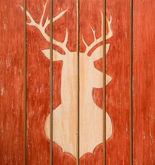 The figure of a deer carved on wooden texture