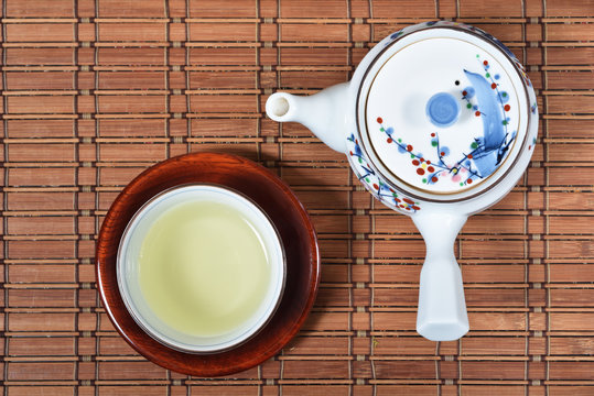 Japanese green tea and teapot on bamboo mat