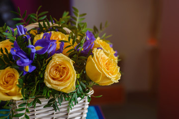 Part of a bouquet of yellow roses in a basket close-up