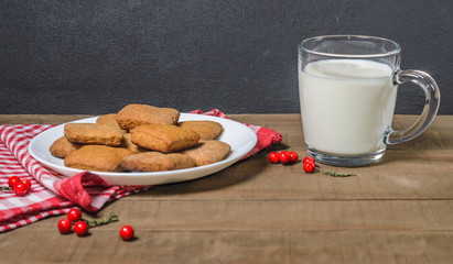 Biscuits, milk, red napkin, Christmas decor with free space for text.