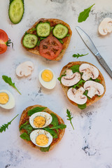 Ciabatta for breakfast. Sandwiches with arugula, egg, mushrooms, cucumbers and tomatoes