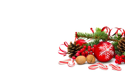 Christmas decoration with branch of christmas tree, candies, walnuts, red berries, cones pine and Christmas ball with snowflake on white background with space for text