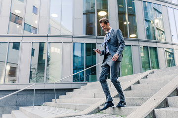 businessman walking downstairs in an office park