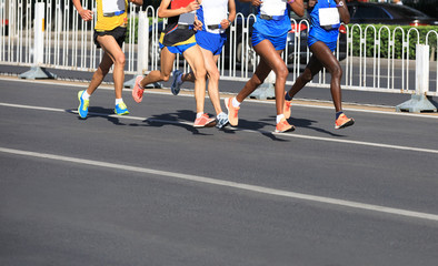 female and male marathon runners running on city road