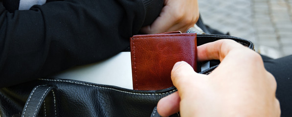 The panorama of Thief stealing the wallet from the bag, close-up