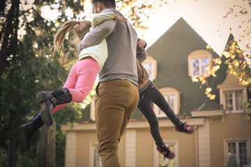 Spinning little girls around, father have fun with daughters.