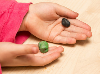 children's hands playing with plasticine